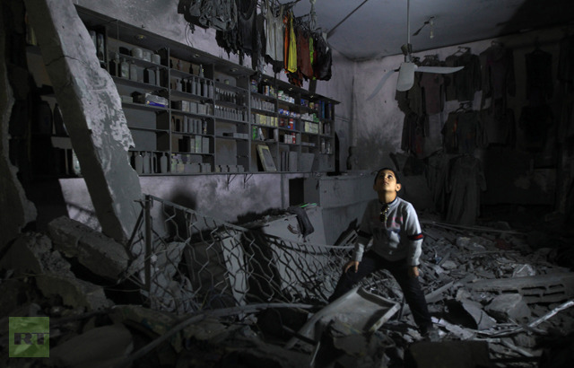 A boy looks up as he walks in the rubble of a destroyed shop in Beit Lahia, in the northern Gaza Strip, on November 26, 2012 (AFP Photo / Mahmud Hams) 